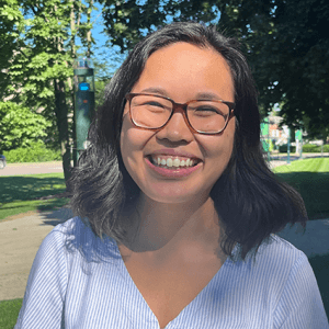 A broadly smiling Jenn, out on a blue-sky, sunny day on UVM green