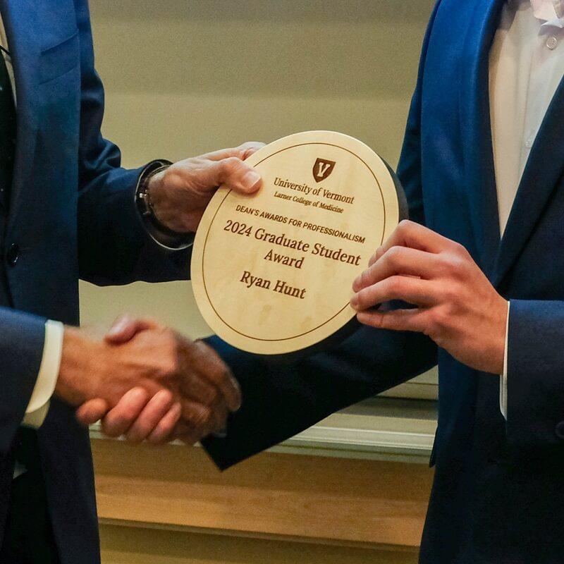 close up hands of person giving award plaque to another person