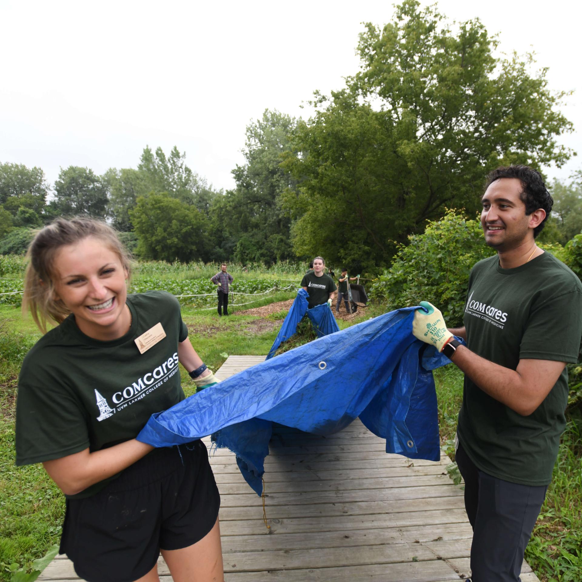 two students pulling a tarp