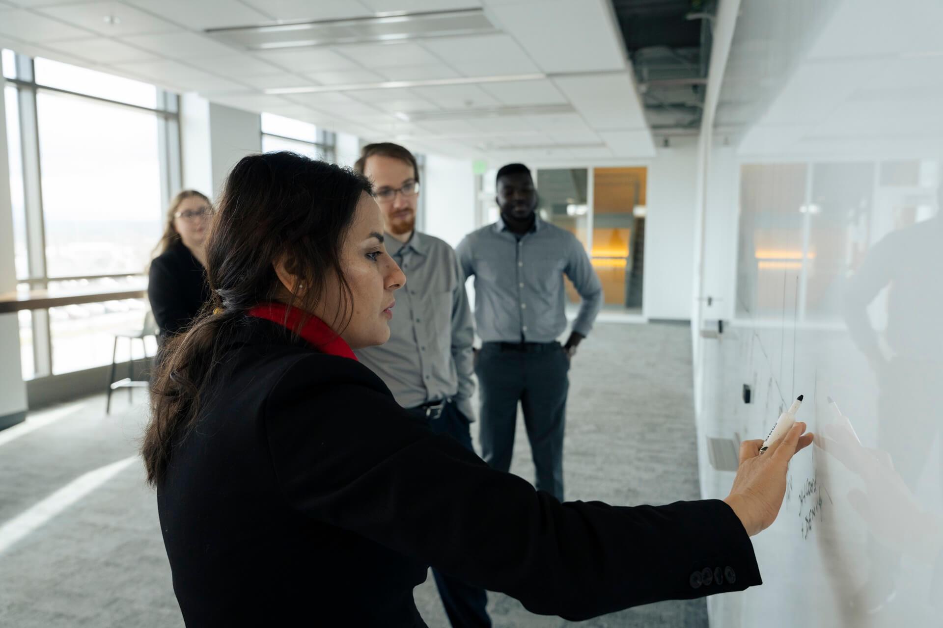 Researcher and students at whiteboard