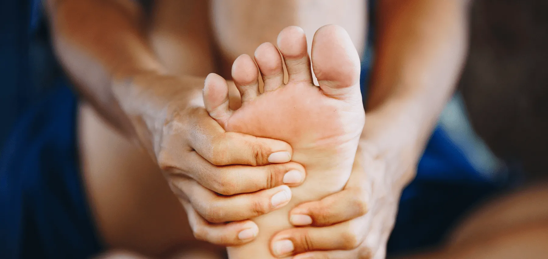 Person holding their own foot with their hands.