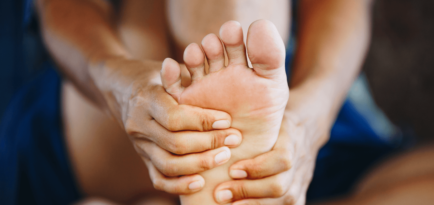 Person holding their own foot with their hands. 