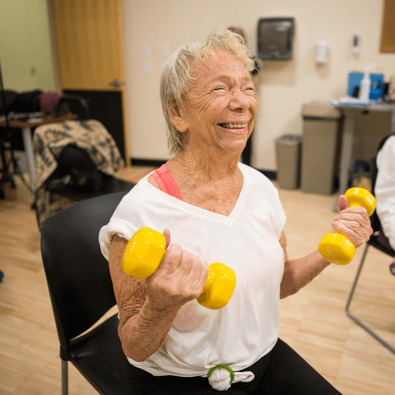 UVM Cancer Center Steps to Wellness participant lifting weights.