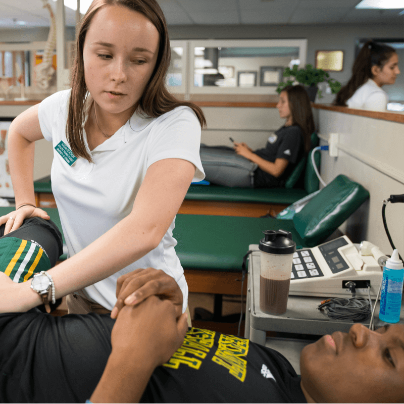 A physical therapy student works with a UVM athlete
