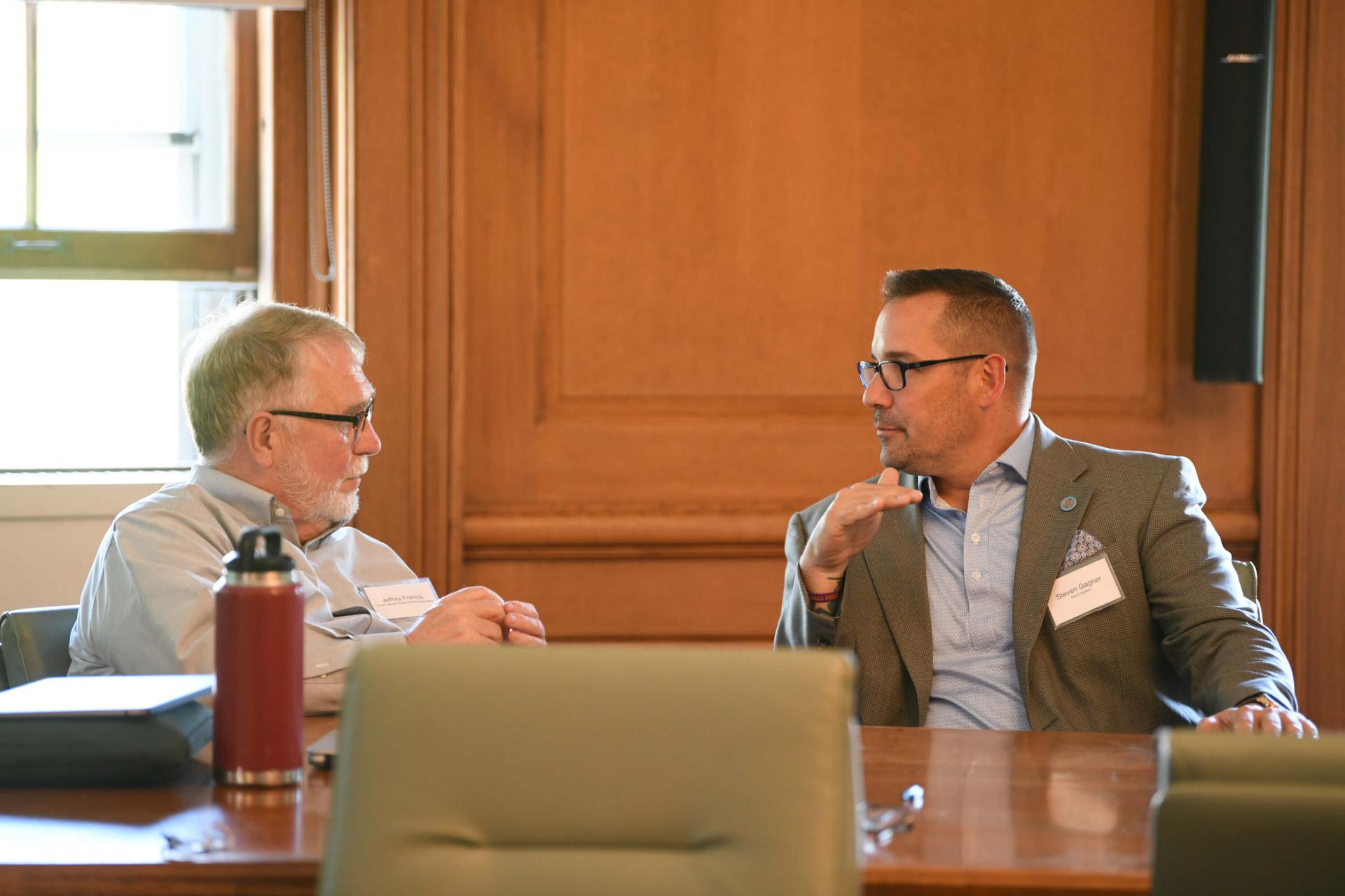 Discussion between two colleagues in a meeting.