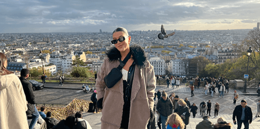 Isabelle stylishly dressed with a sprawling cityscape behind her