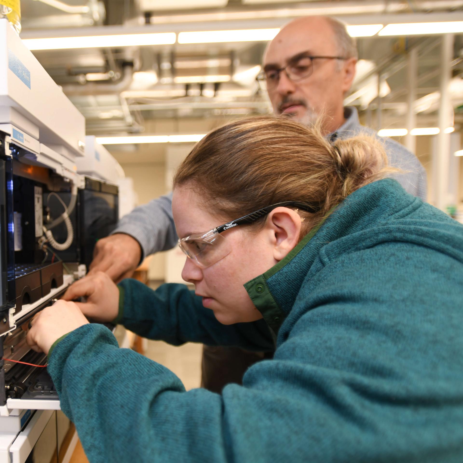 Researchers working on lab equipment