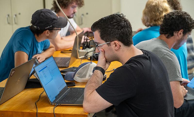 CEMS student working on his laptop in a lab