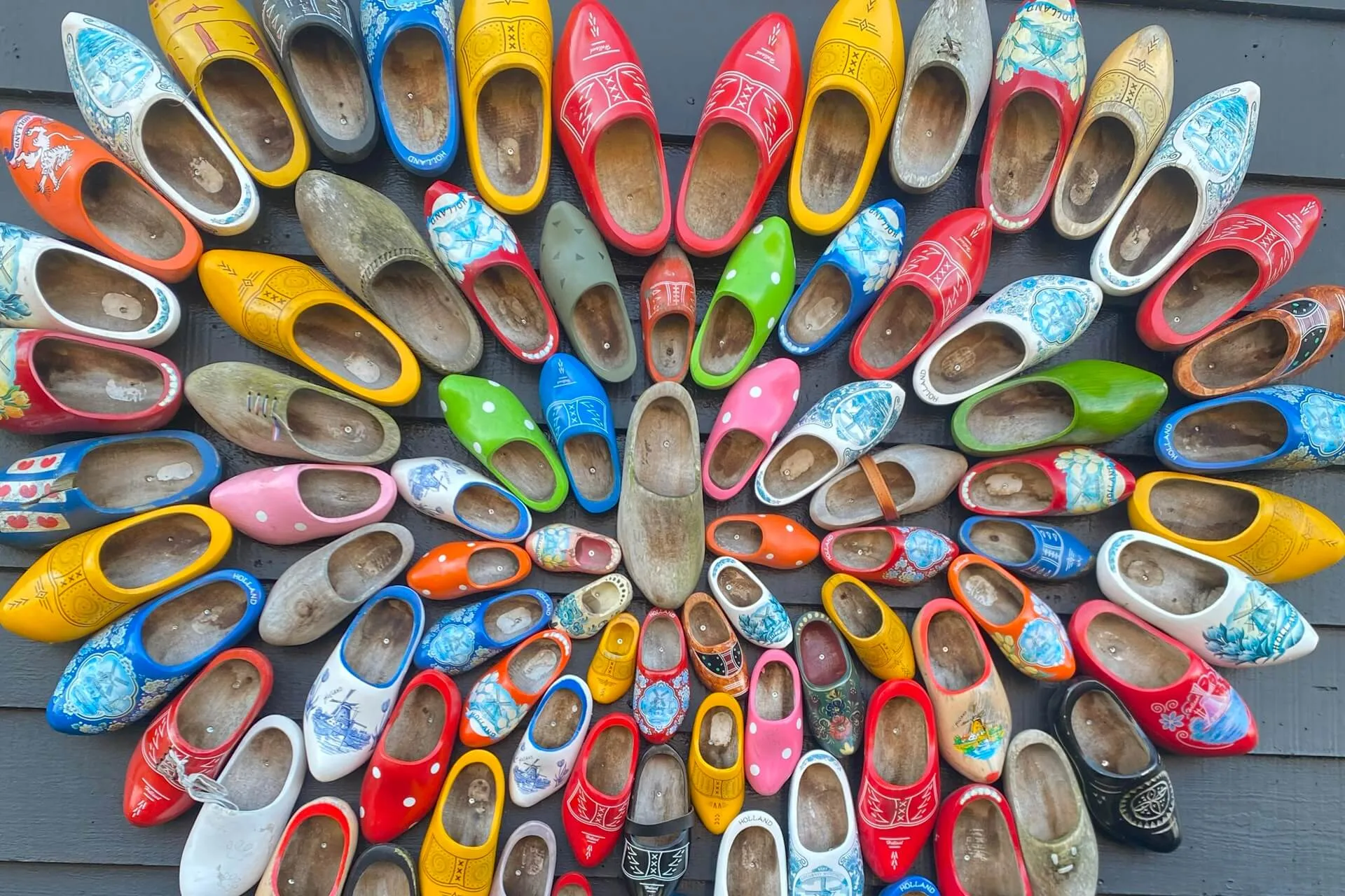 array of many colorful wooden clogs in a heart shape