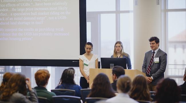 Students giving presentation in front of audience.