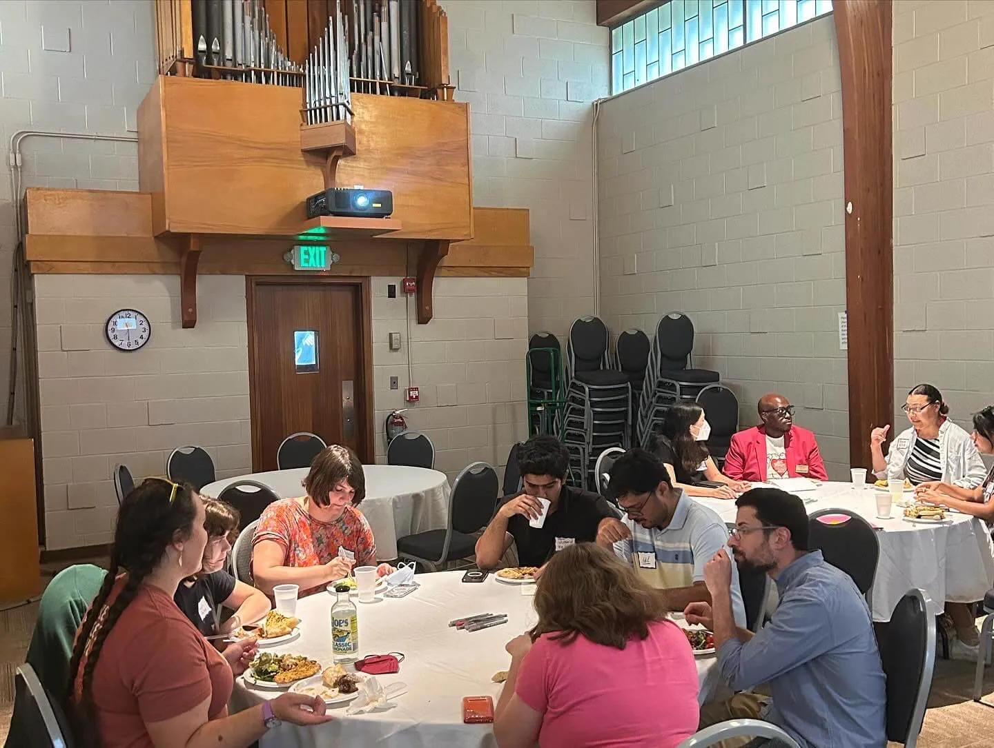groups of people sitting in round tables and eating food