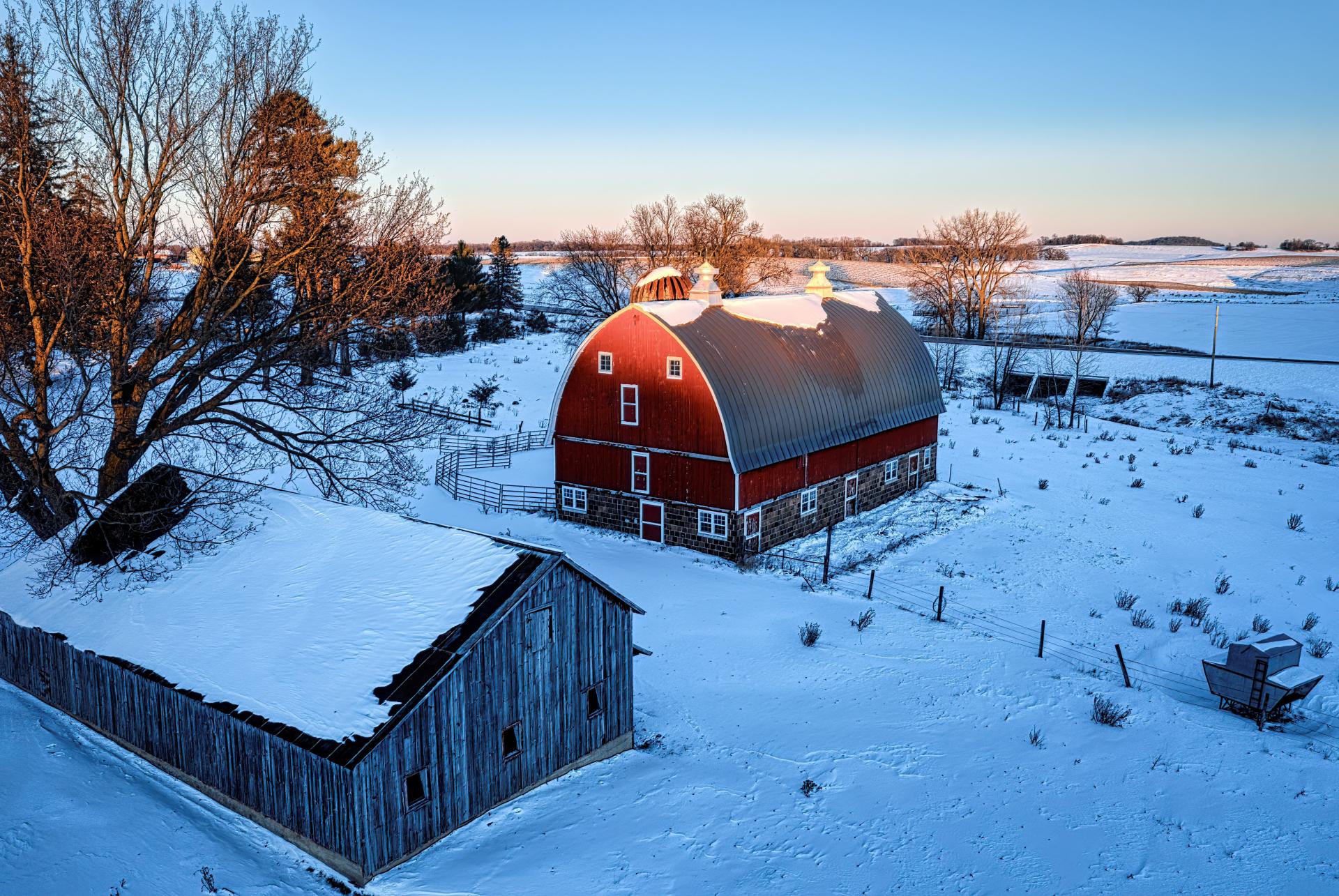 A farm in winter with a sunset. 