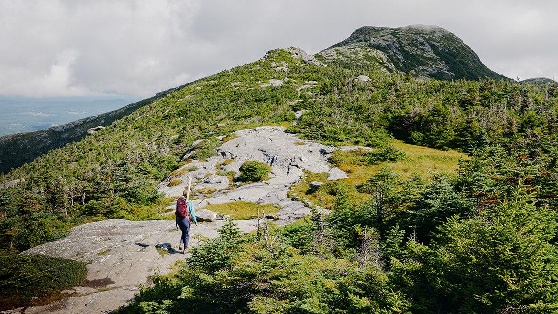 A researcher hikes near the summit of a mountain