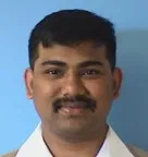 A man with black hair wearing a white shirt