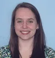 A woman with dark brown hair wearing a floral shirt