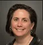 A woman with black hair wearing a black shirt