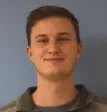 A man with brown hair wearing a sweater