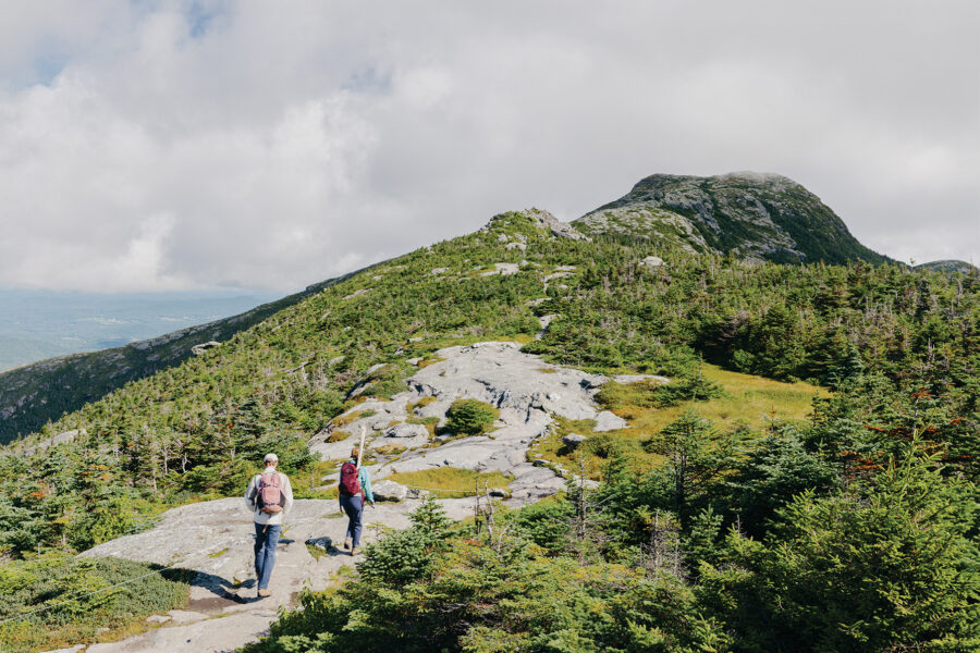 Two hikers walking on top of Mount Mansfield