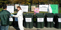 student eco-reps sort recycling in front of a row of trash cans
